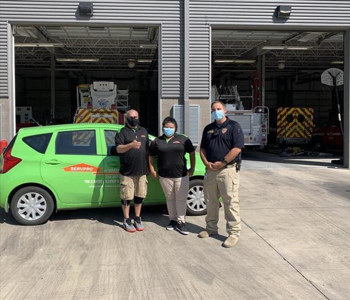 Two SERVPRO technicians stand with Leon Valley Fire Department Assistant Fire Chief Eric Burnside