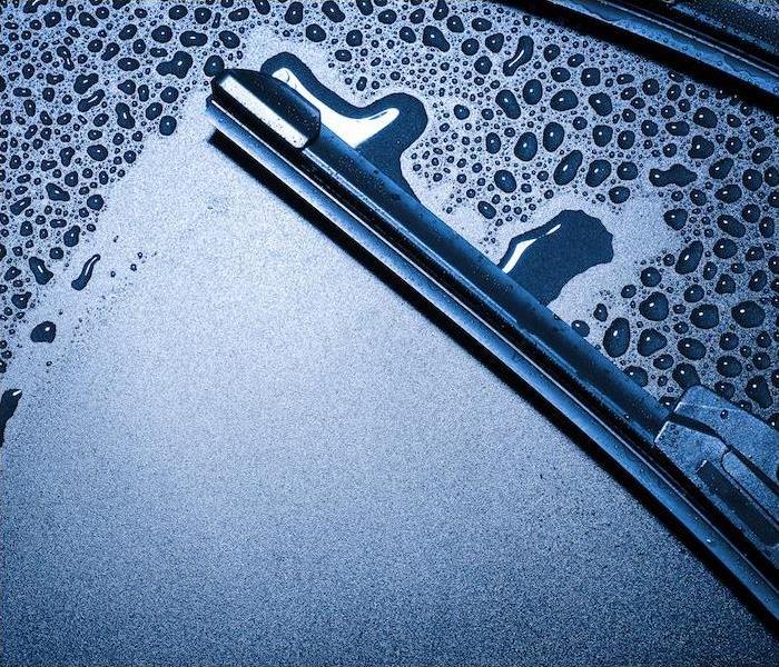 a close-up image of a wiper blade wiping away condensation on a car windshield